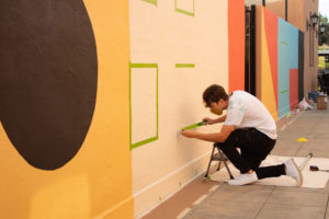 Artist painting mural on wall